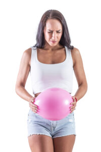 נפיחות בבטן: תמונה של אישה עם בלון על הבטן